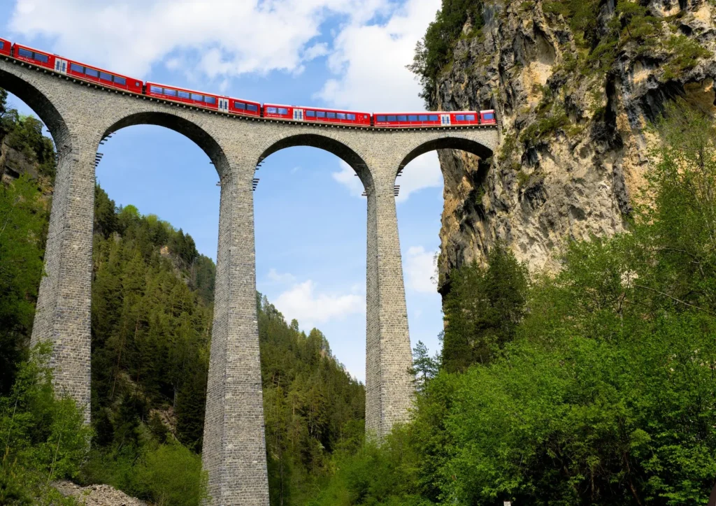 Train rouge franchissant un viaduc dans les Alpes suisses
